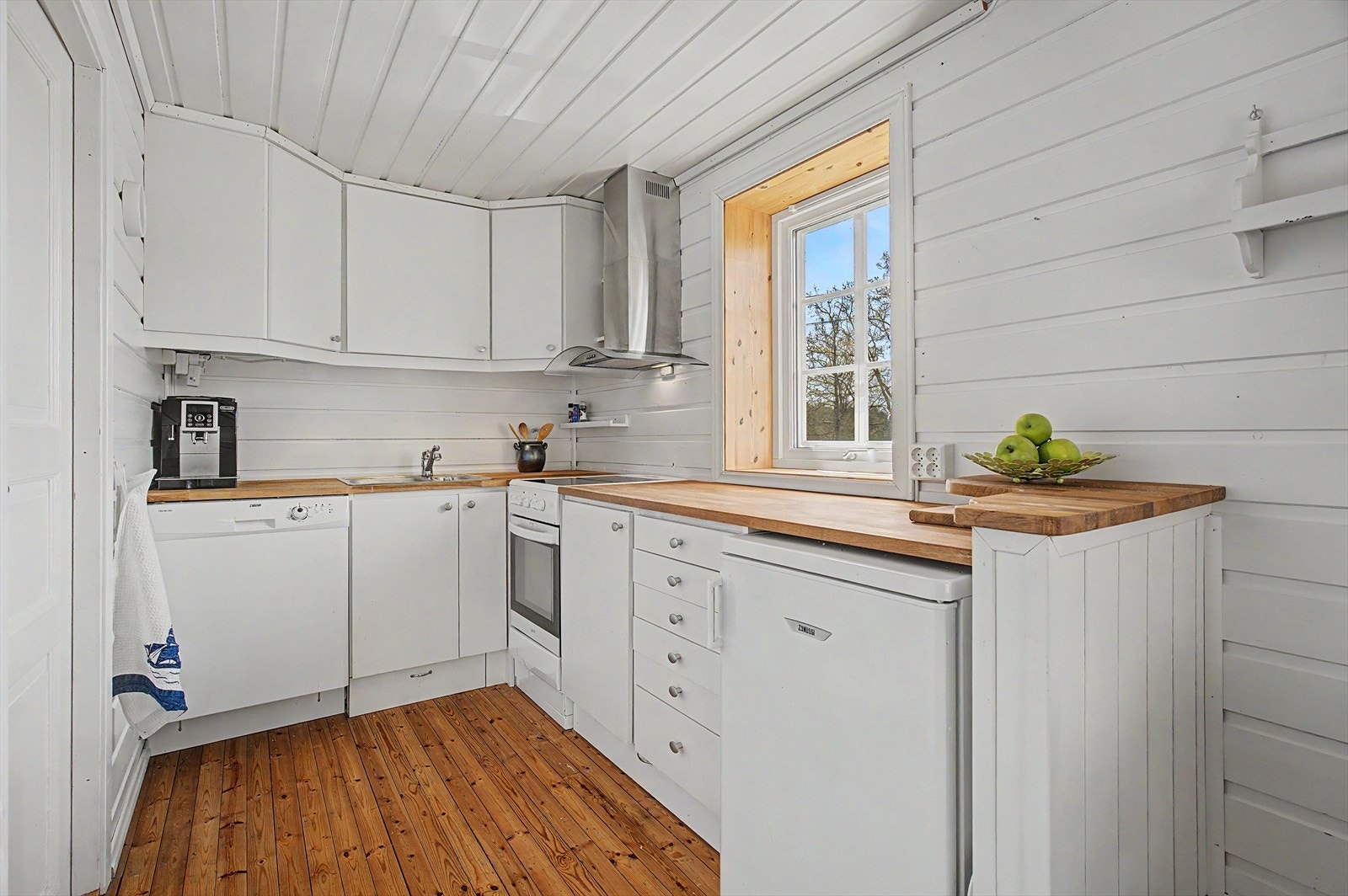 Kjøkkenet har innredning med glatte fronter og en benkeplate i heltre. Galleribilde
