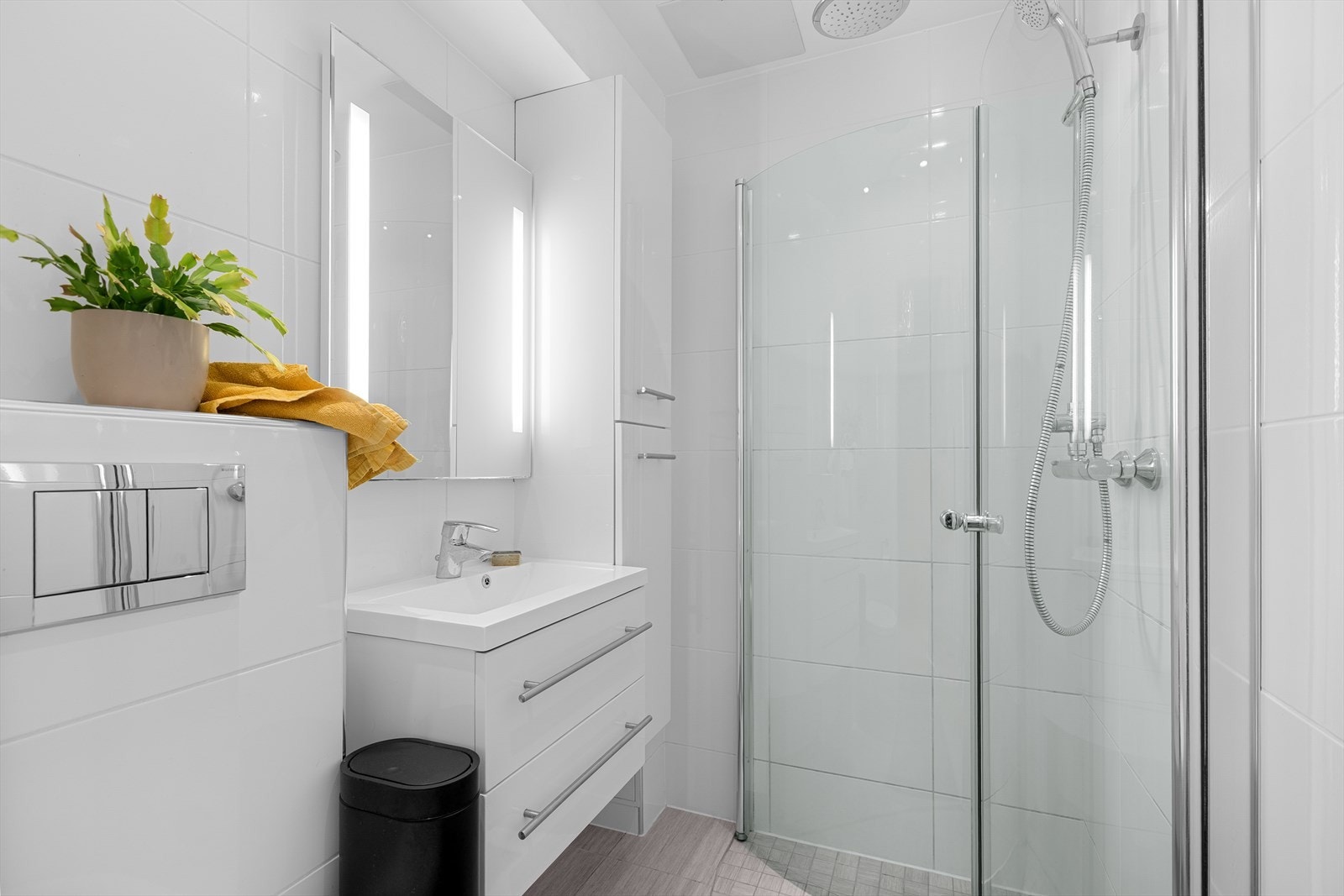 Badet er innredet med vegghengt toalett, servantmøbel og speilskap. Galleribilde