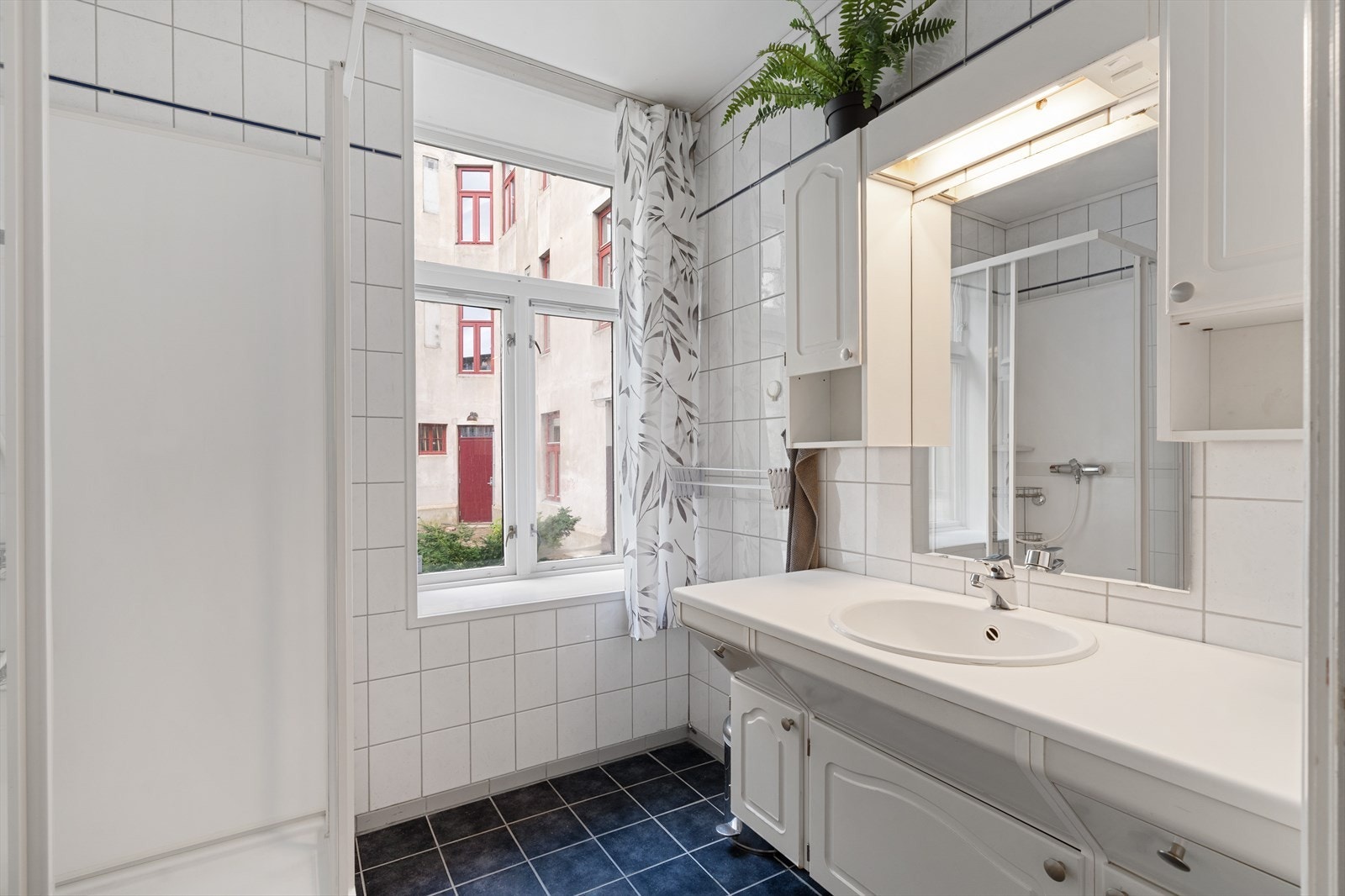 Flislagt bad på 4,5 m² med praktisk baderomsinnredning. Galleribilde