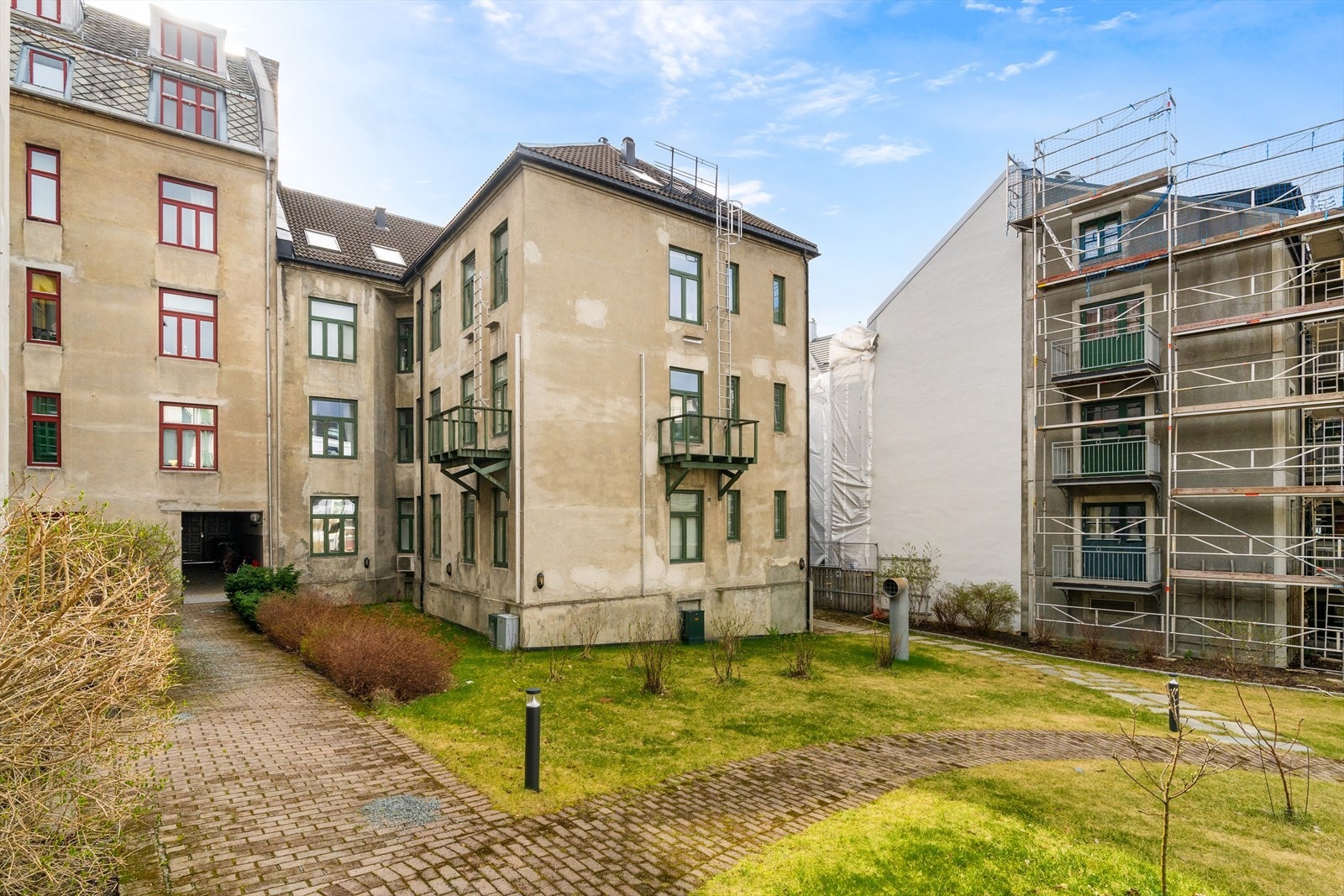 Frodig og stor bakgård med bærbusker, utemøbler og lekeplass. Galleribilde