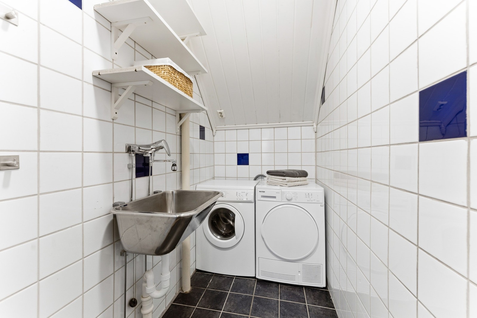 Praktisk vaskerom med skyllekum, opplegg for vaskemaskin og tørketrommel. Galleribilde