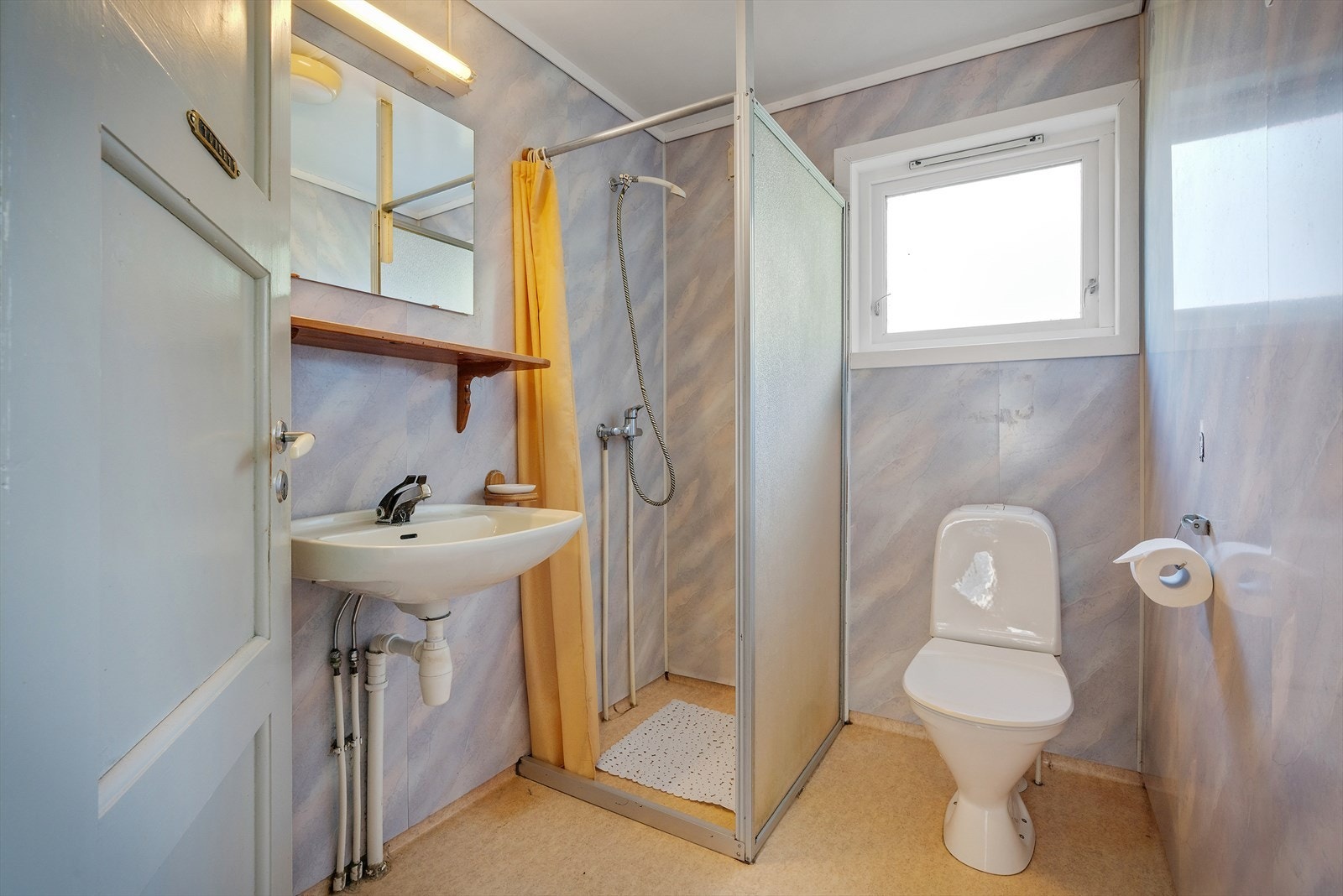 Badet ligger i boligens første etasje og er innredet med servant, toalett og dusjløsning. Det er varme i gulvet. Galleribilde