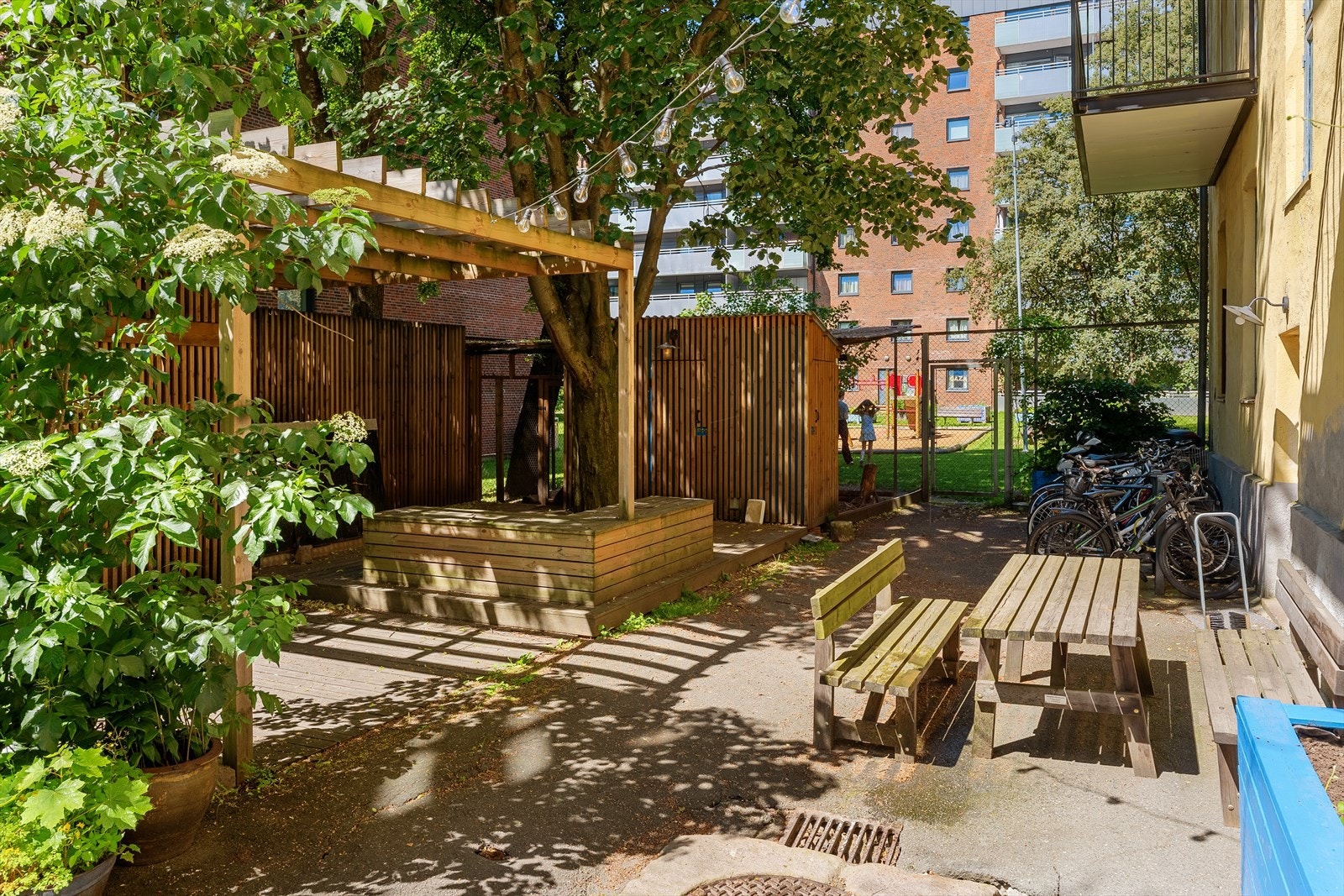 Pent opparbeidet felles bakgård med bl.a sykkelparkering, inngang til lekeplass, sittebenker m.m Galleribilde