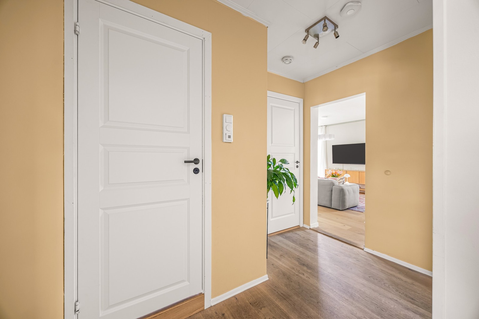 Ut i gangen hvor det er laminatgulv fra 2022, glatte veggflater i Cheerful Peach" og malte takflater i "Vanilje" for en lunere finish Galleribilde