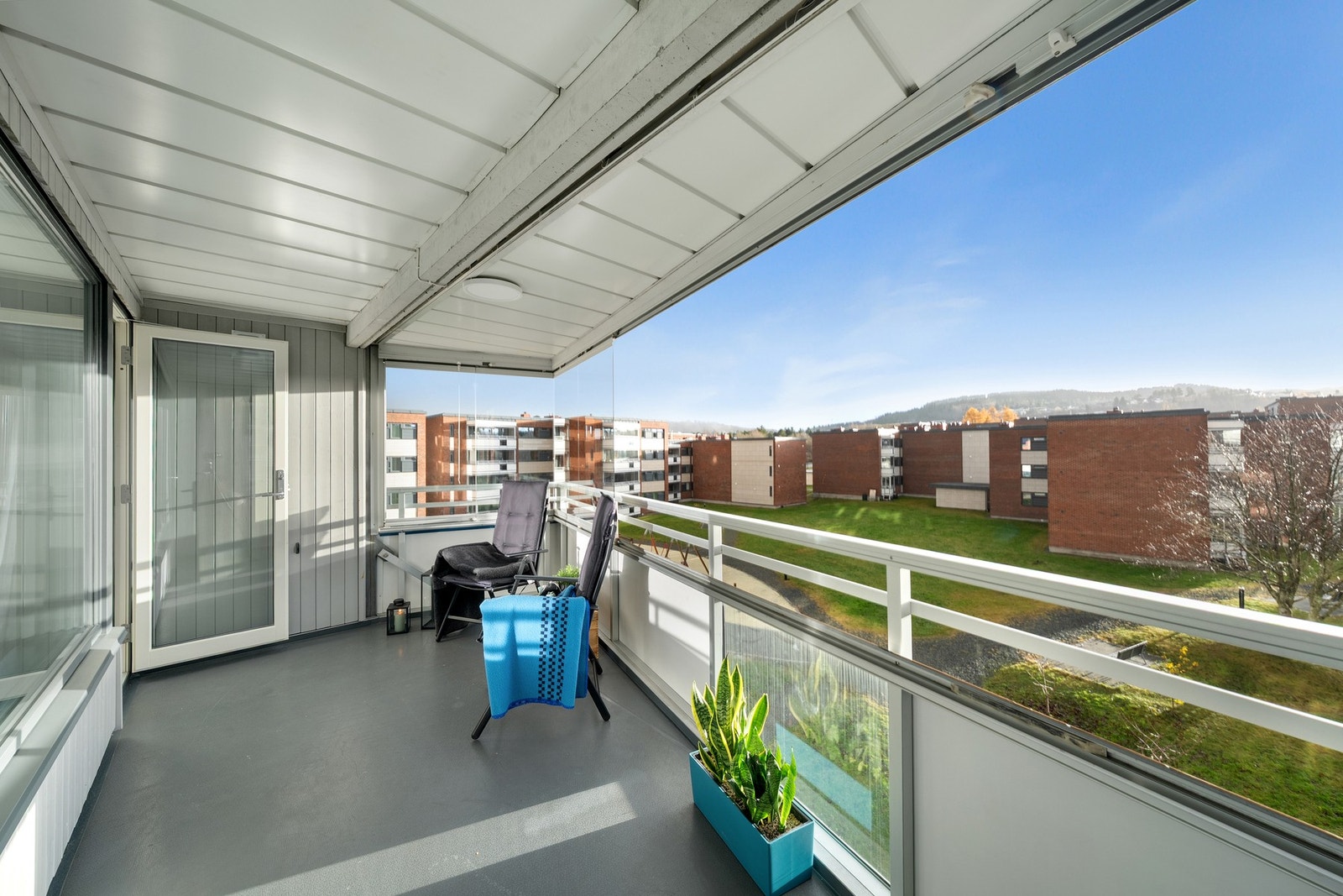 Det er verdt å nevne at balkongen er innglasset og at man kan åpne helt opp ved å skyve glassene til siden når solen steker. Fin utsikt over grøntarealer og lekeplasser. Galleribilde