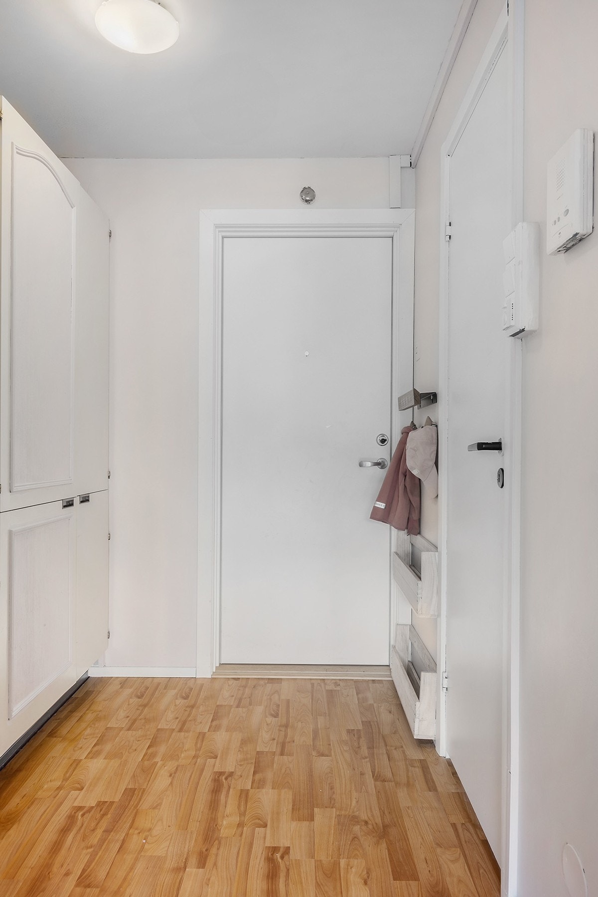 Her ønskes du velkommen inn i en romslig entré. Det er garderobeskap for oppbevaring av klær og sko, og dørcalling med åpner. Galleribilde