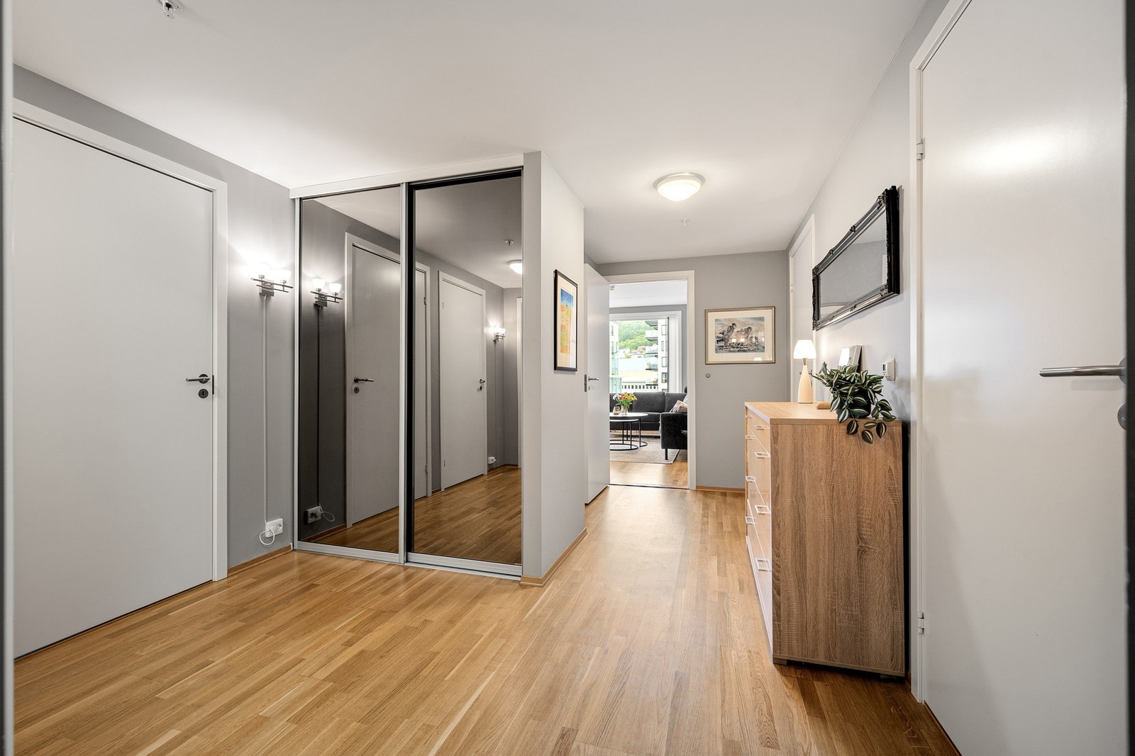 Romslig og innbydende entré med praktisk skyvedørsgarderobe Galleribilde