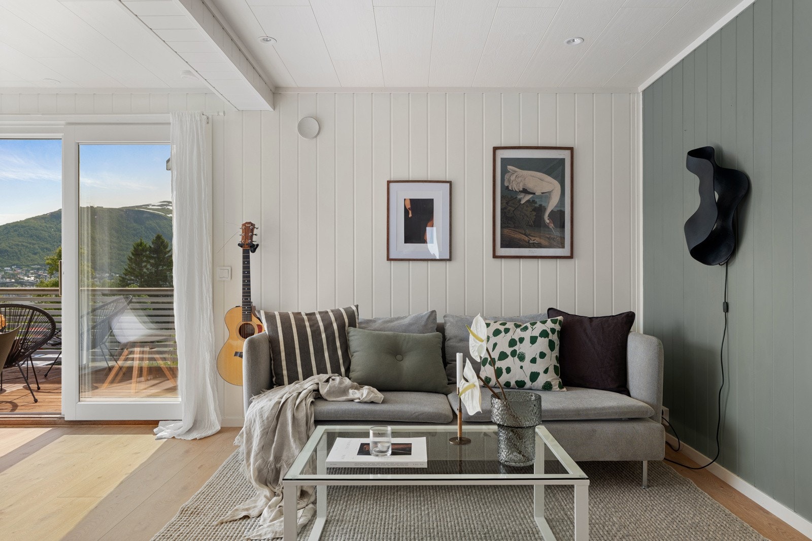 Romslig stue som er malt i tidsriktige farger. Her er det god plass til sofa med tilhørende møblement.