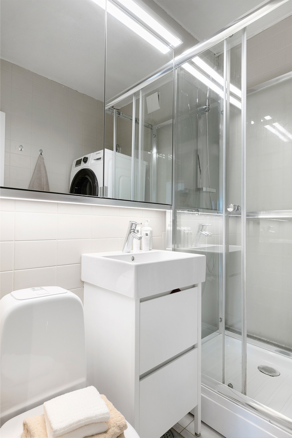 Badet har en innredning bestående av dusjkabinett, servant og frittstående toalett. Galleribilde