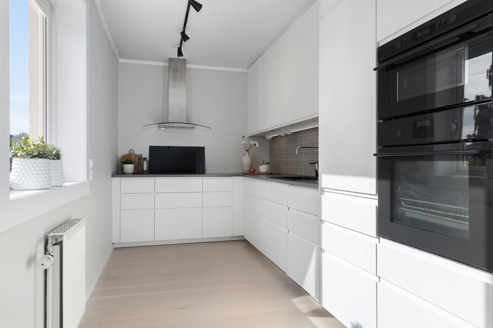 Moderne kjøkken med slette fronter og laminat benkeplate. Galleribilde