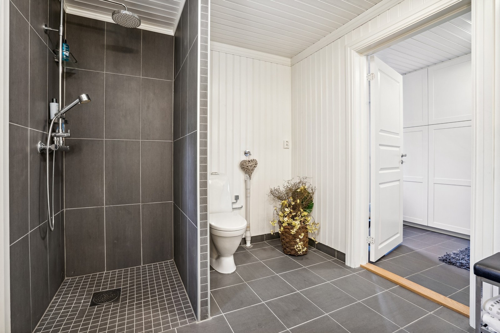 Et meget romslig bad med dusjhjørne og opplegg til vaskemaskin. Galleribilde