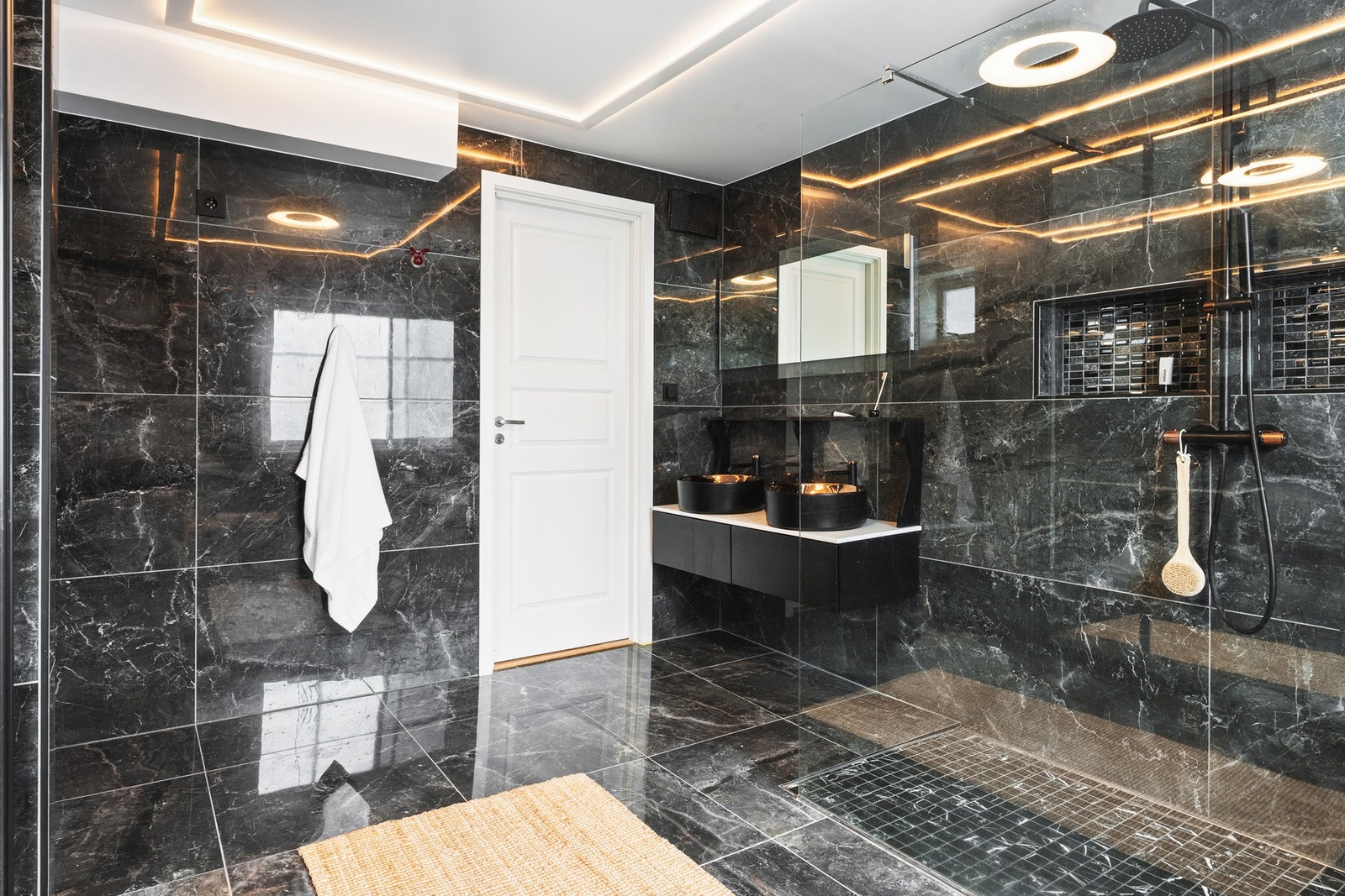 Badet har dusj med glassvegg, vegghengt toalett, baderomsinnredning og opplegg for vaskemaskin. Det er også tilrettelagt for badekar. Galleribilde