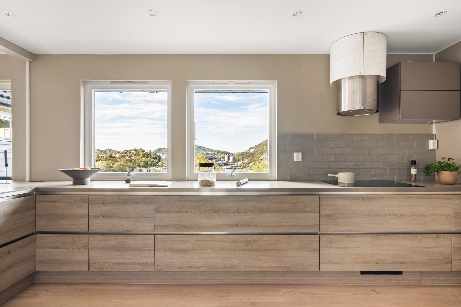 Videre inn i boligen møter du et romslig kjøkken med moderne, slette fronter og laminat benkeplate. Galleribilde