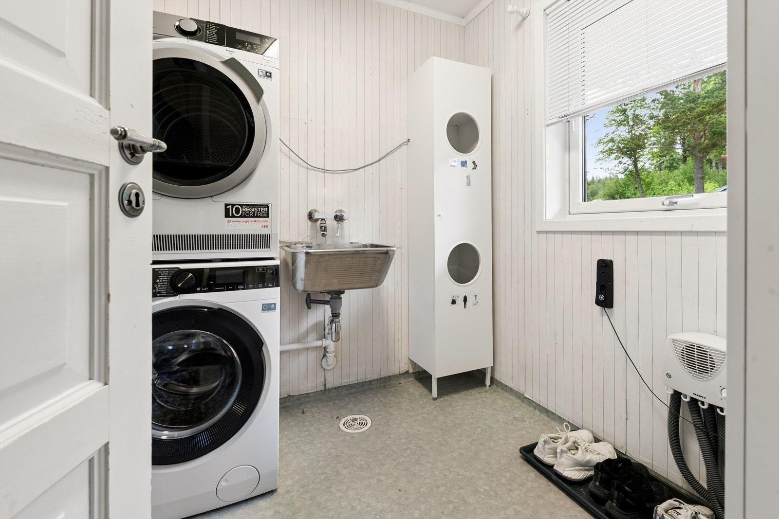 Praktisk vaskerom fra byggeår med opplegg for vaskemaskin og vinylbelegg på gulv. Galleribilde