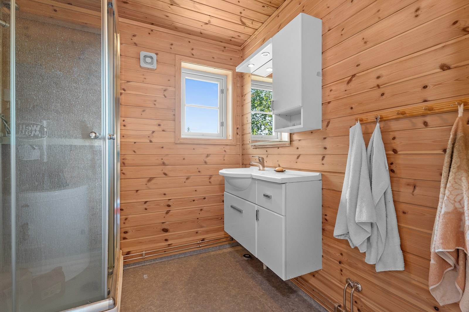 Lyst og praktisk bad på ca. 4 m² med dusjkabinett, servant og vindu som gir godt med naturlig lys. Galleribilde