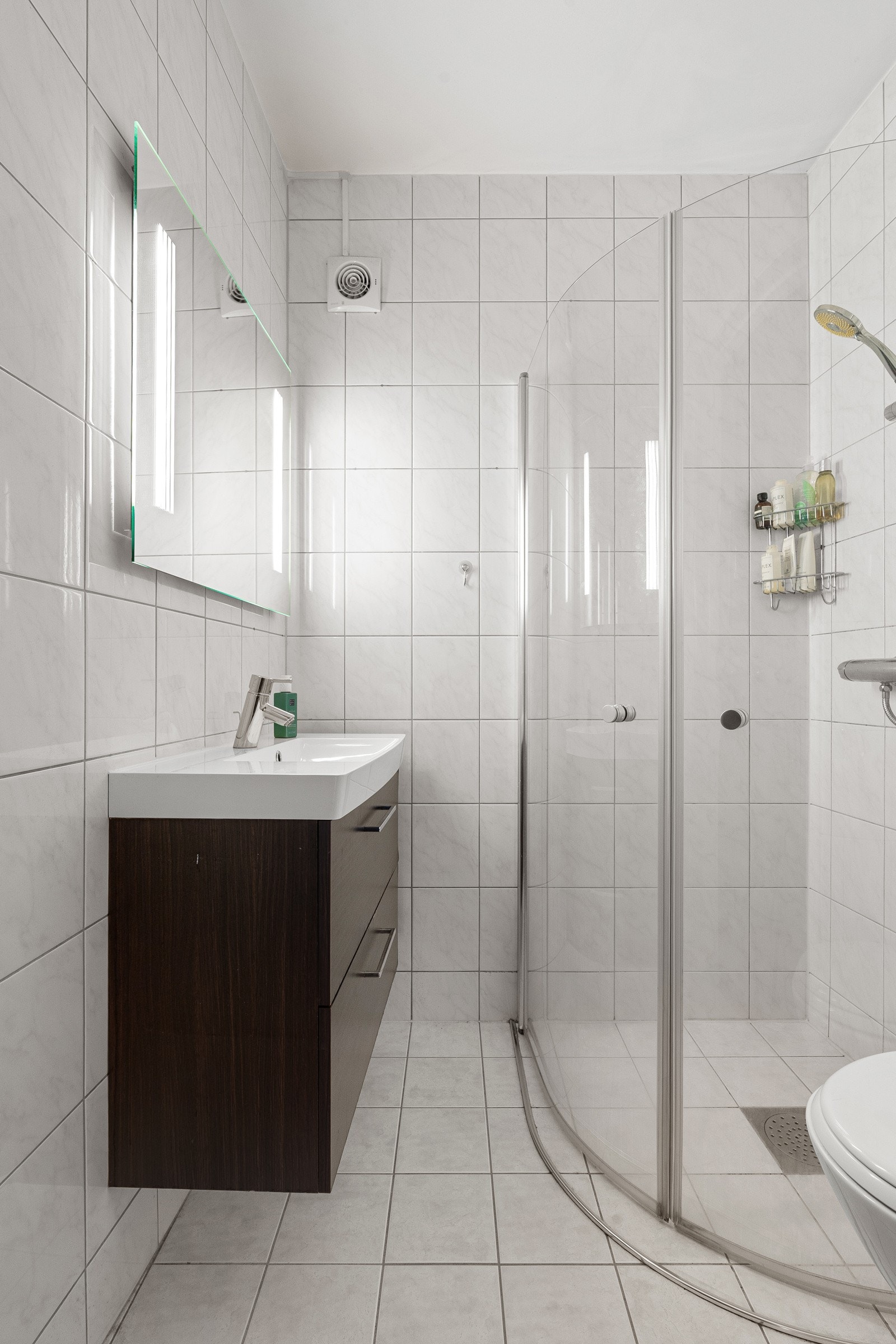 Flislagt bad med dusjhjørne og wc.