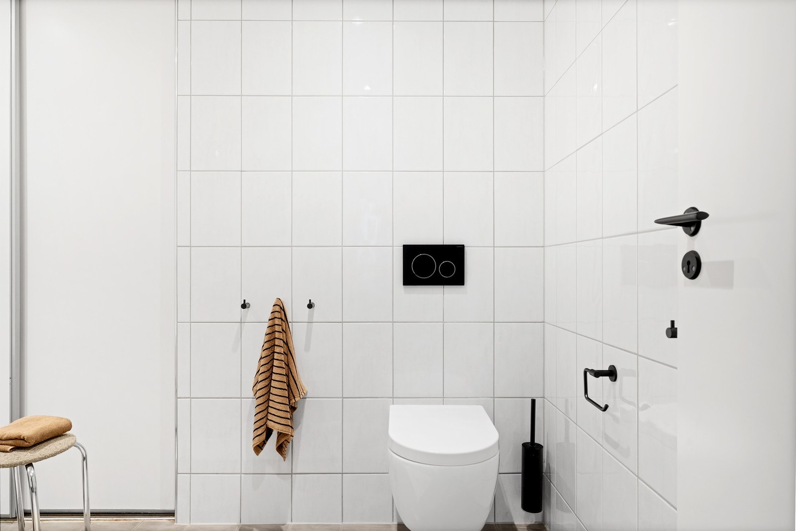 Badet er innredet med vegghengt toalett, badekar med dusj, og vask med underskap. Galleribilde