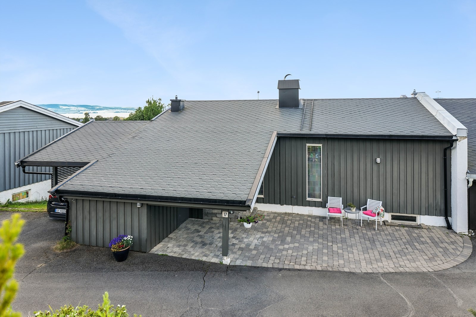 Inngangsparti med biloppstillingsplass. I tillegg er det carport med elbil-lader. Galleribilde
