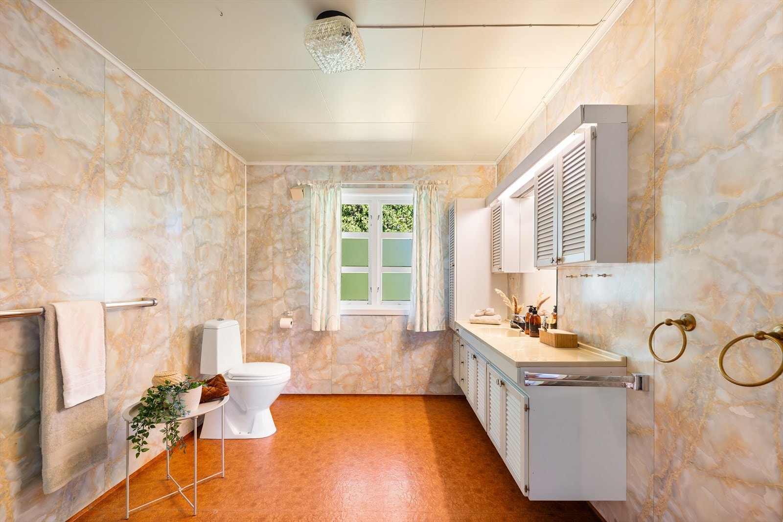 Badet i første etasje har baderomsplater på veggene og rikelig med skapplass. Galleribilde