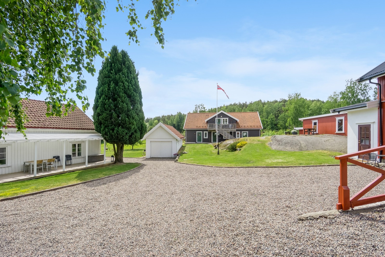 Gårdsplassen mellom våningshuset og låven, tregjerde og port ut mot veien Galleribilde