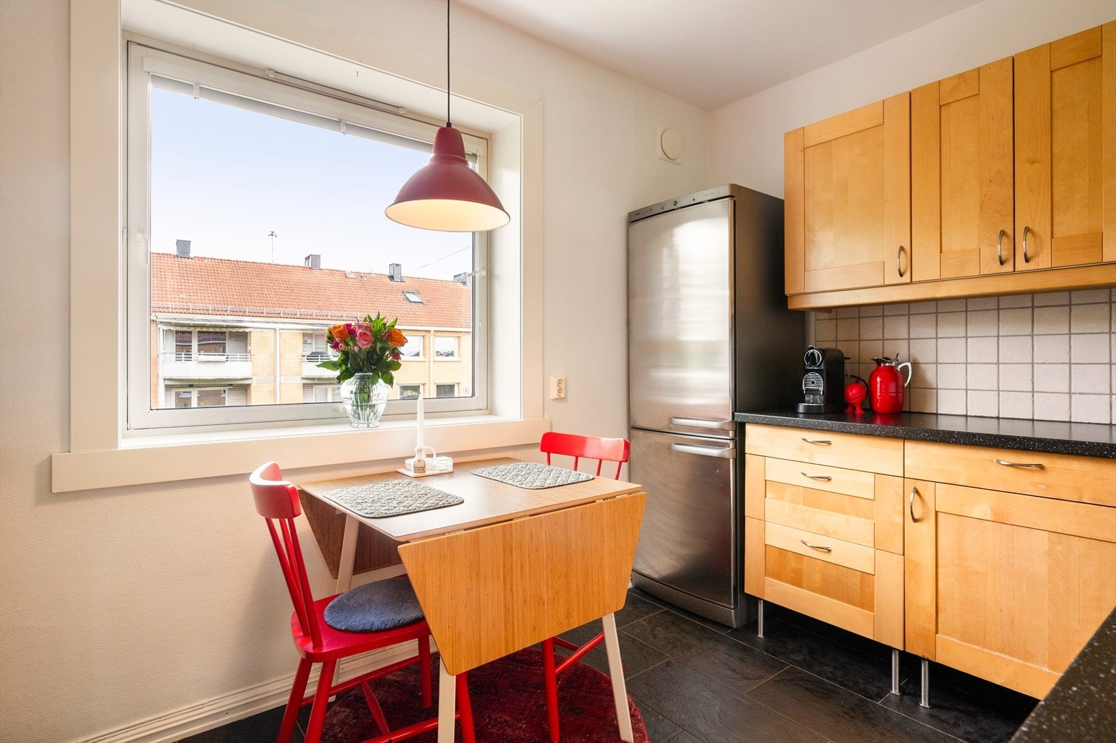 Kjøkkeninnredning med profilerte fronter, fliser og belysning over benkeplaten, laminat benkeplate med nedfelt vask- og skyllekum. Galleribilde