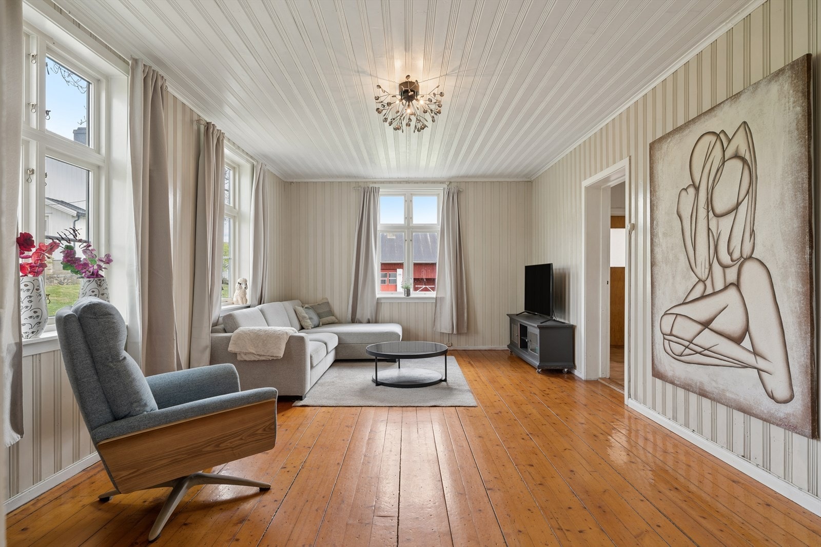 En annen stue med originale tregulv og panelkledde vegger. Galleribilde