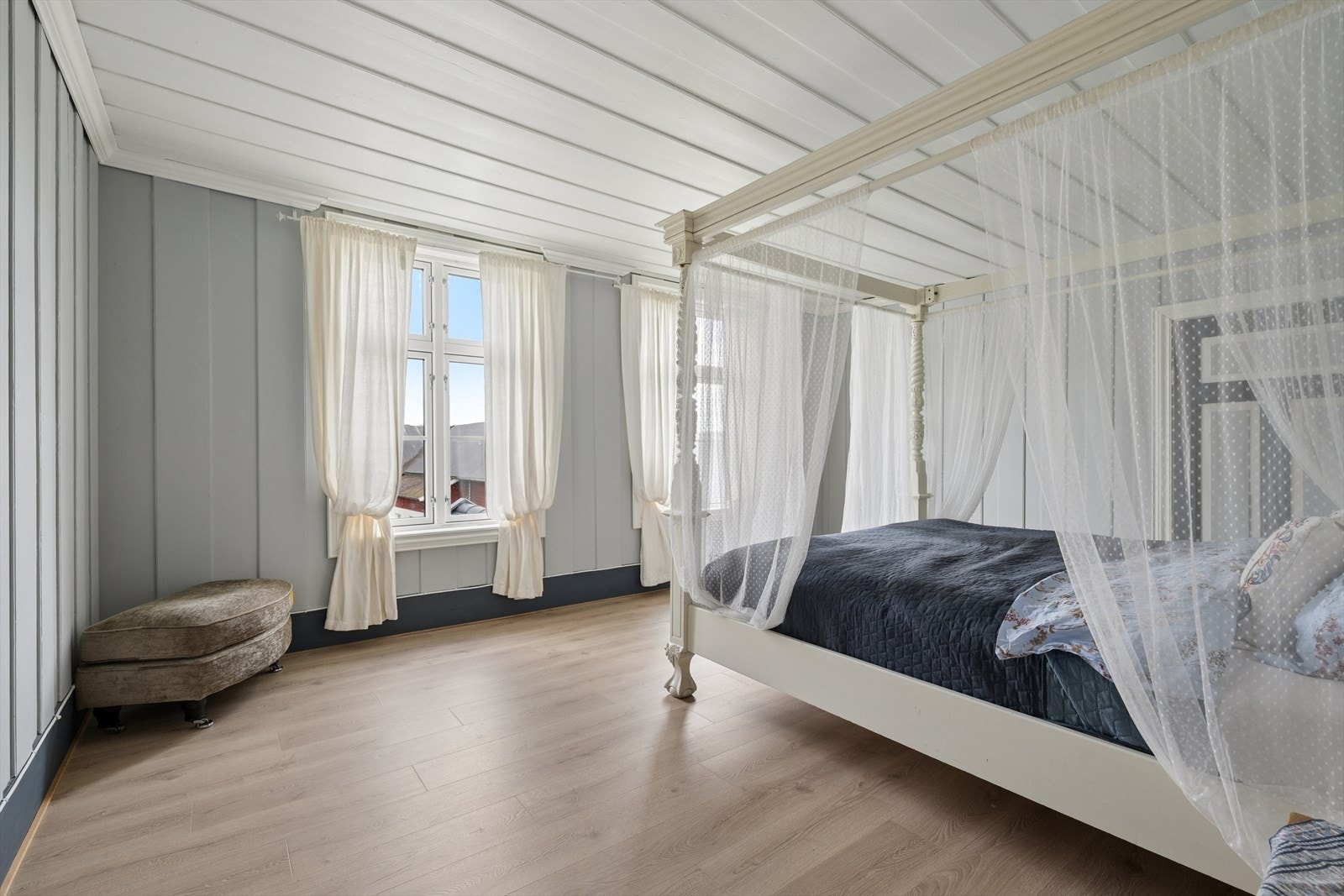 Et av de mange soverommene, med laminatgulv og panel på veggene. Galleribilde