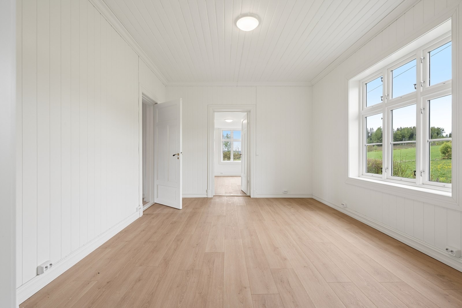 Gjennomgående laminatgulv og panel på vegger og i tak gir en helhetlig stil. Galleribilde