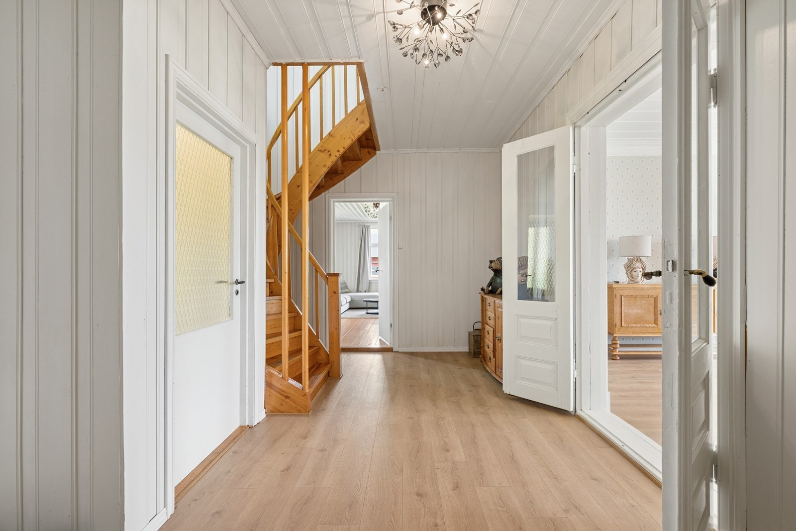 En lys entré ønsker velkommen, med tilgang til flere av boligens rom og trapp til andre etasje. Galleribilde