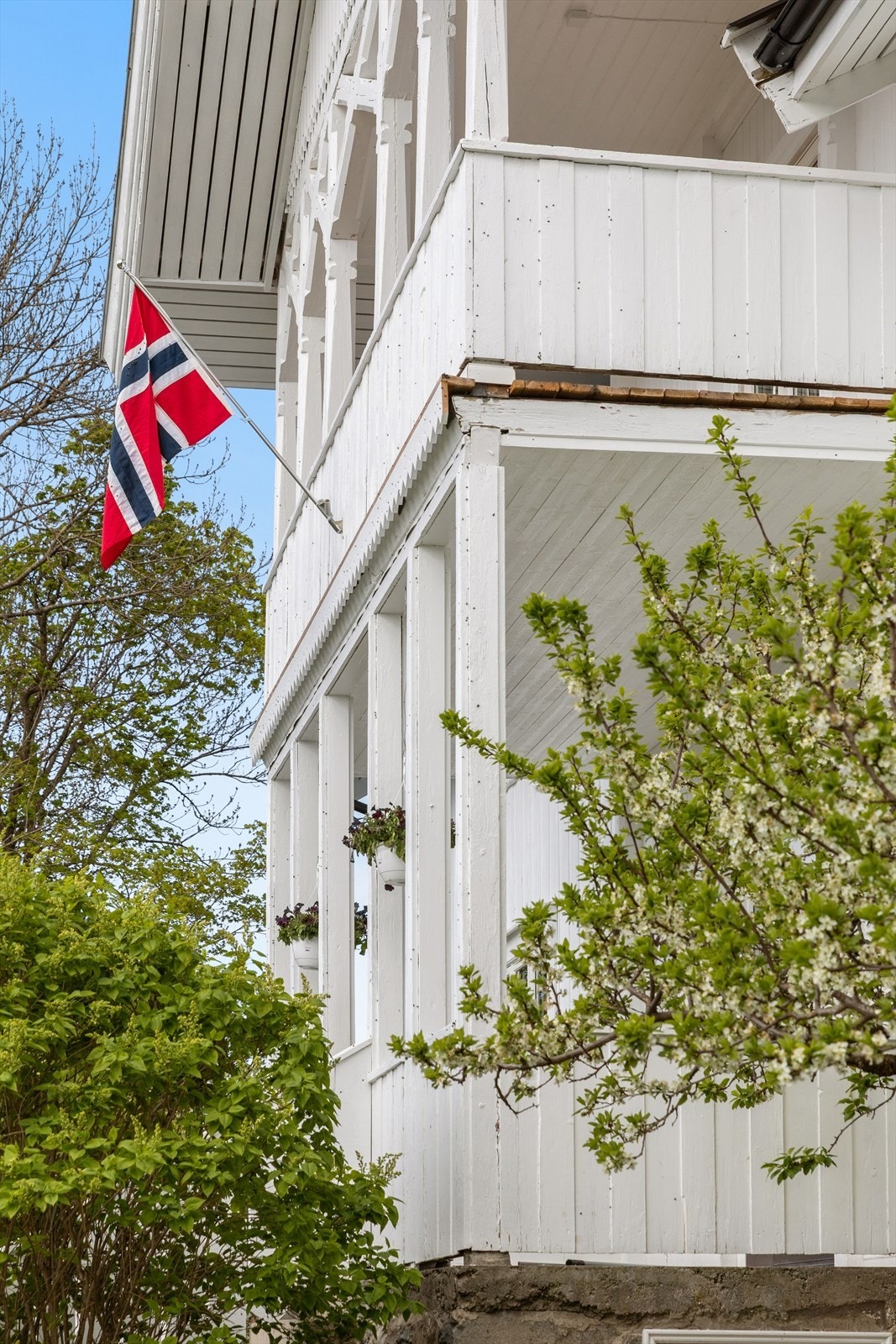 Detaljer som slanke søyler og malt trepanel kjennetegner verandaen. Galleribilde