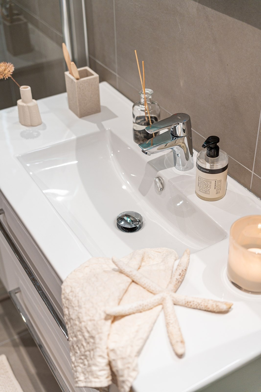 Badet inneholder vegghengt toalett, innredning med servant og dusj Galleribilde
