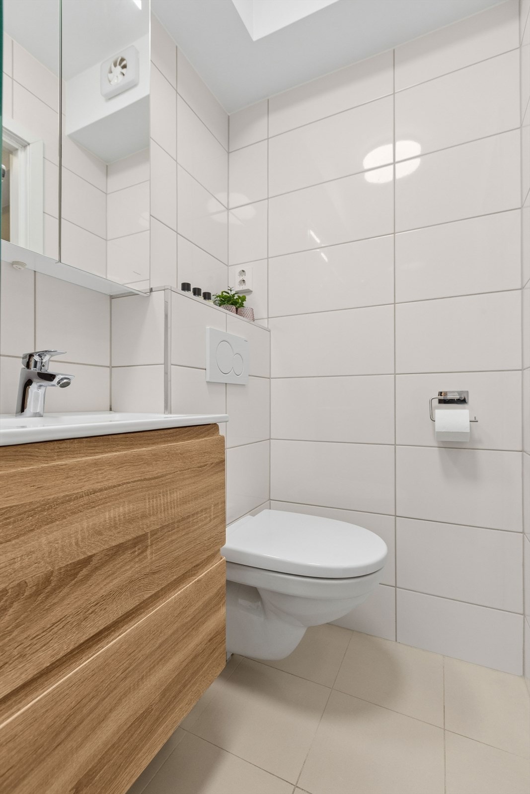 Badet er utstyrt med vegghengt toalett og servantinnredning med god oppbevaringsplass. Galleribilde