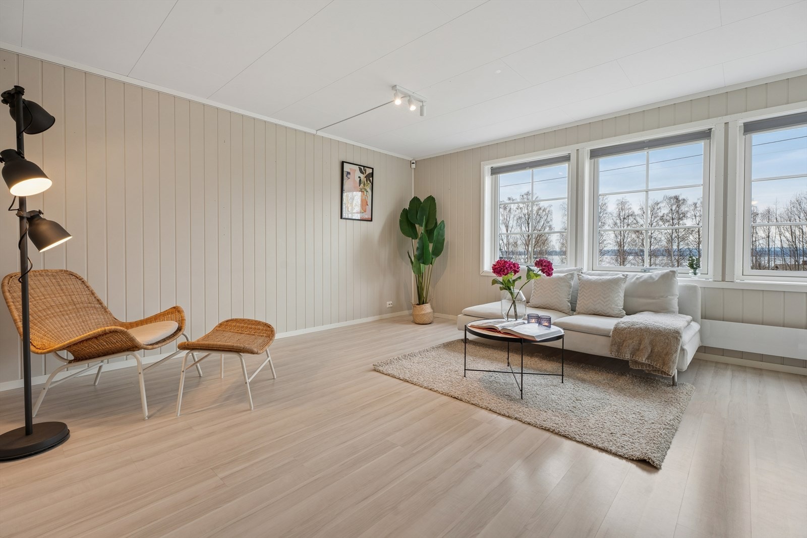 Gjennomgående laminatgulv og vegger med panelplater skaper et helhetlig og lyst uttrykk i boligen. Galleribilde