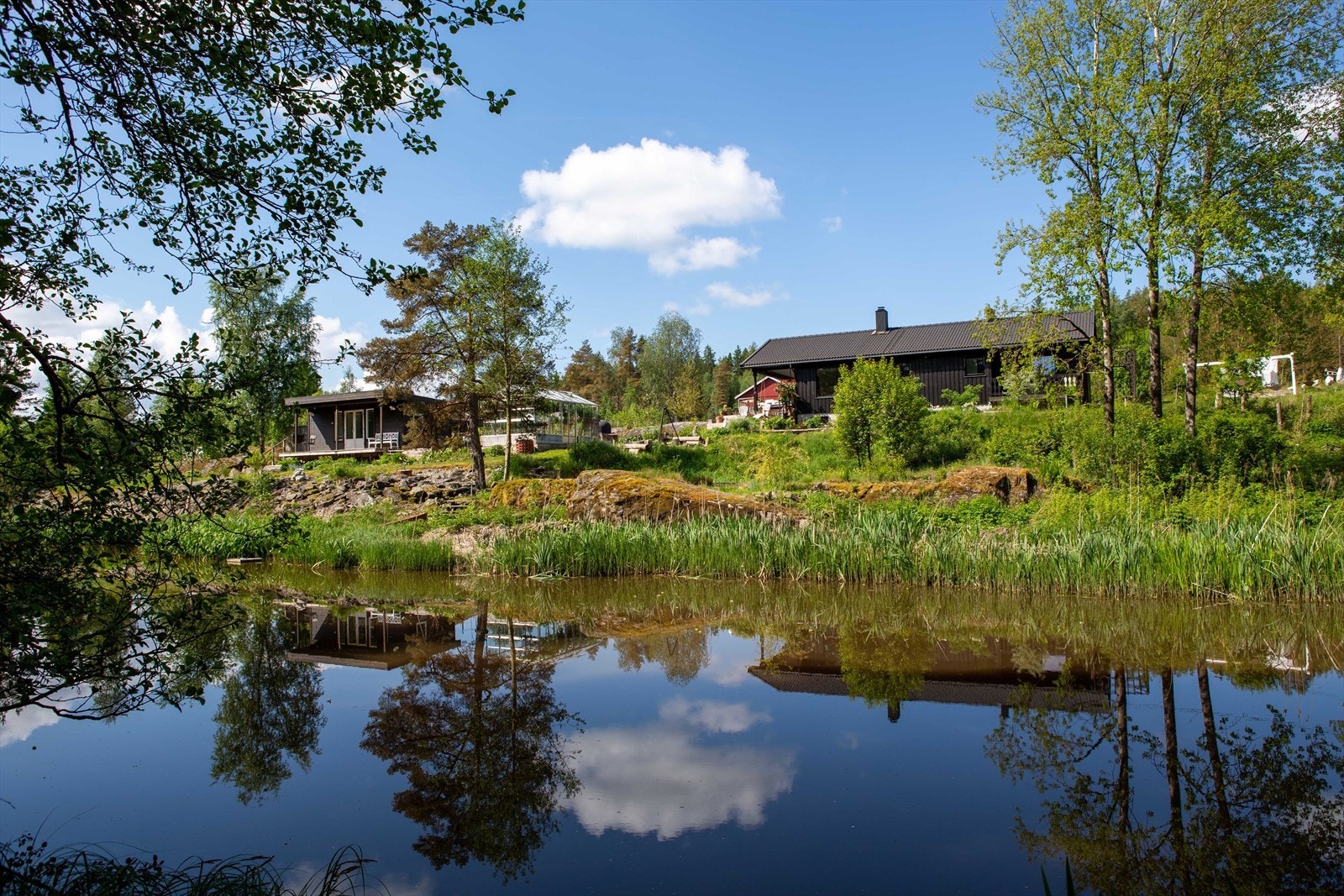 DnB Eiendom v/Elisabeth Moe har gleden av å presentere Fosserveien 60! En flott enebolig m/alt på ett plan, anneks, drivhus og dobbel garasje.
Eiendommen sett fra andre siden av elven. (selgers bilde) Galleribilde