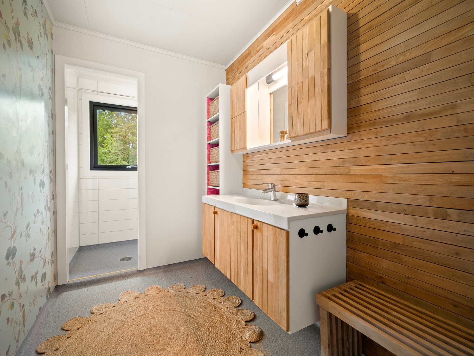 Badet ligger i husets 1.etasje. Baderommet har baderomsplater på vegg og vinylbelegg på gulv, samt innredet med nedfelt servant og dusjvegger/hjørne. Galleribilde