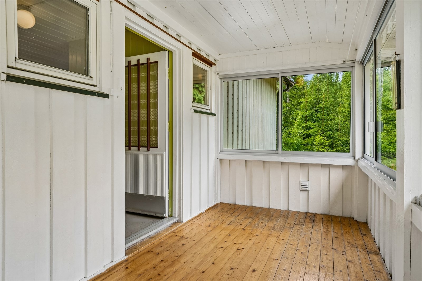 Overbygget og innglasset inngangsparti med lakkert tregulv. Galleribilde