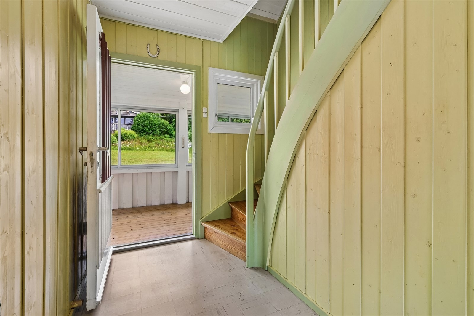 Entré med linoleumsfliser og en malt vinkeltrapp som fører til andre etasje. Galleribilde