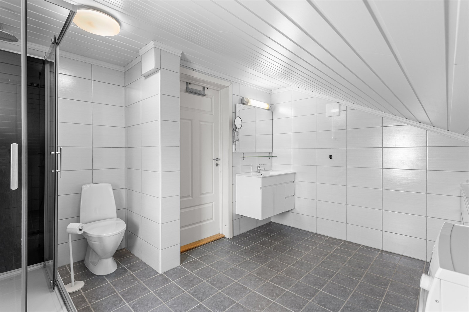 Utleiedel i 2. etasje: Flislagt bad med gulvvarme. Innredet med vegghengt servantinnredning og ovenpåliggende servant. Dusjkabinett og gulvstående toalett. Opplegg for vaskemaskin. Galleribilde