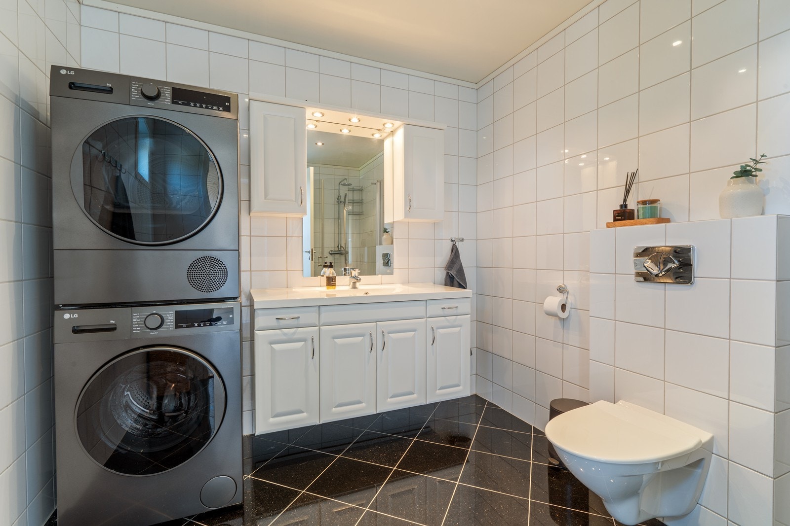 Bad 1 - Badet i leilighetens 1.etg er flislagt med moderne tidløs innredning, samt opplegg for vaskemaskin. Galleribilde