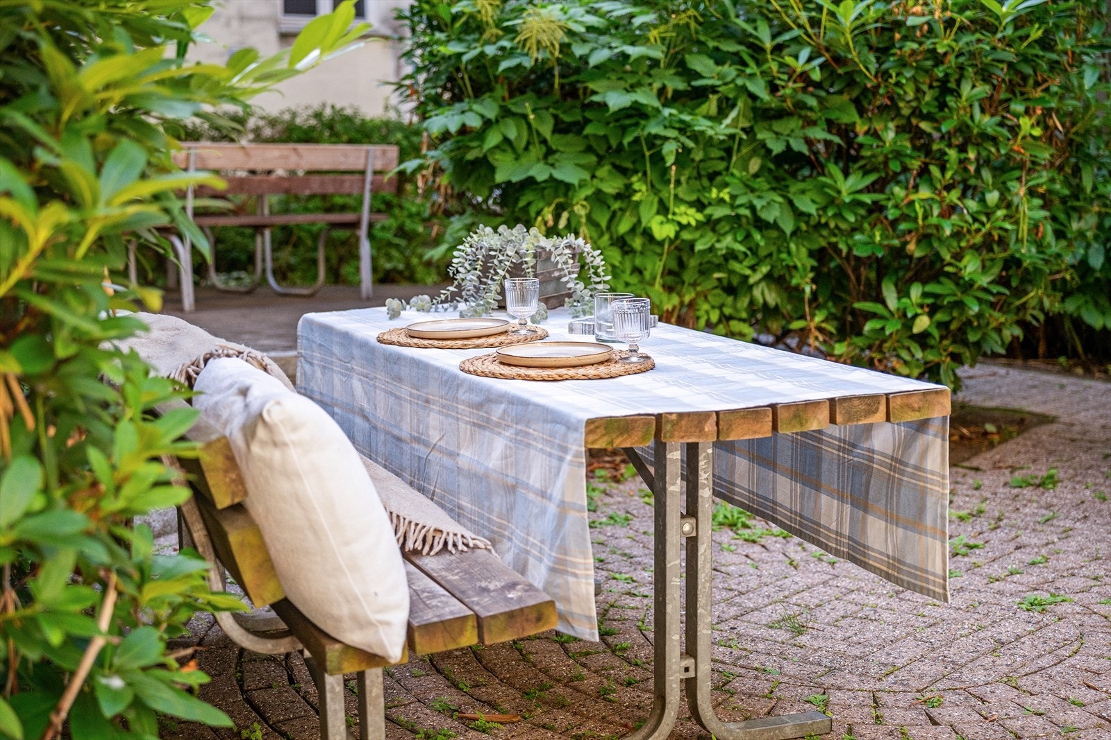 Bakgården er pent opparbeidet med beplantning og flere sittegrupper. Galleribilde