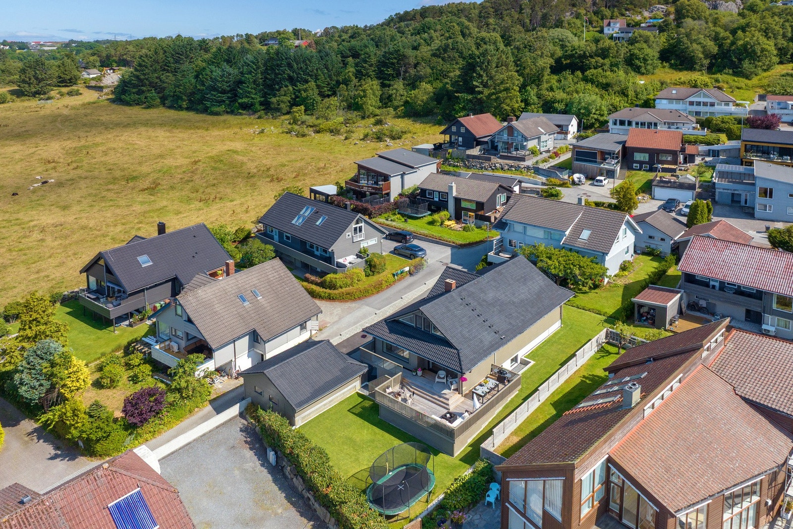 Tomten er opparbeidet med planering i to nivåer og en flat plen som er godt egnet for både lek og aktivitet, samtidig som den fungerer utmerket med robotgressklipper. Det er god plass til trampoline samt en nyplantet hekk. Galleribilde