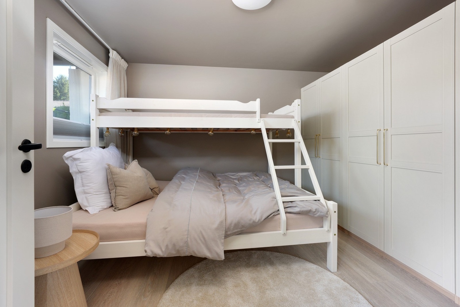 Et lyst og romslig soverom i underetasjen, perfekt ved f.eks. gjester eller tenåringen med tilgang til eget bad i etasjen. Rommet er oppgradert med nye overflater, varmefolie i gulvet og moderne belysning. Galleribilde
