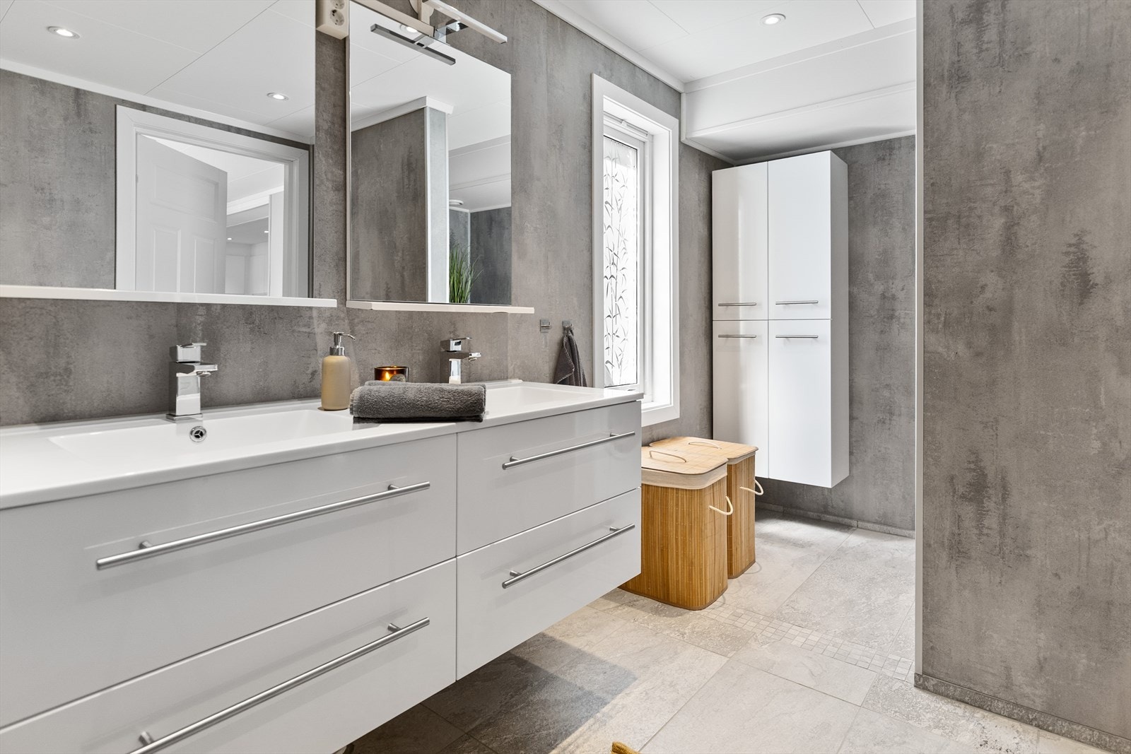 Badet er fra 2021 og har en romslig innredning med to nedfelte servanter. Galleribilde
