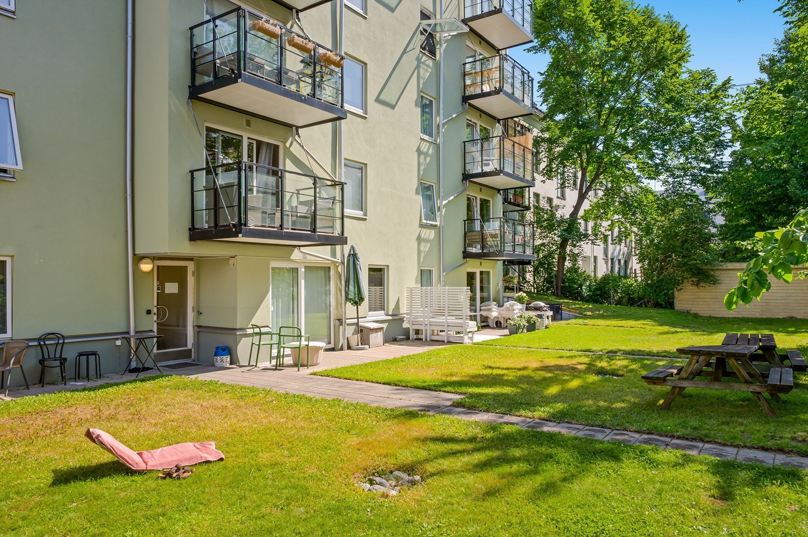 Den opparbeidede bakgården byr på grønne omgivelser og hyggelige sitteplasser - et fint sted å nyte varme sommerdager. Galleribilde