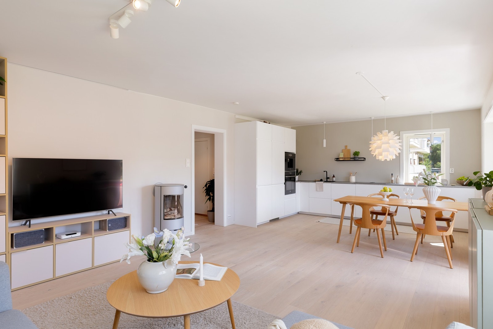 Den åpne løsningen mot kjøkkenet gir en sosial atmosfære med god plass til både sofagruppe og spisebord Galleribilde