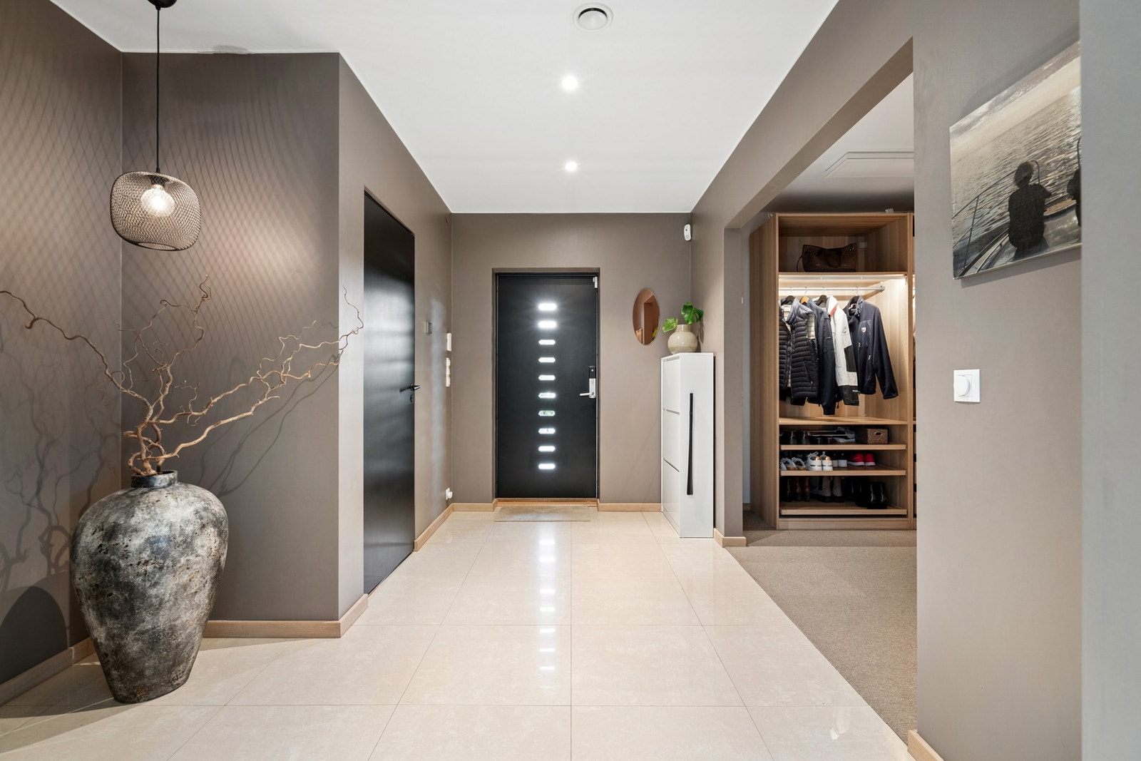Innbydende entré med flislagt gulv og tilknytning til en romslig walk-in-garderobe. Galleribilde