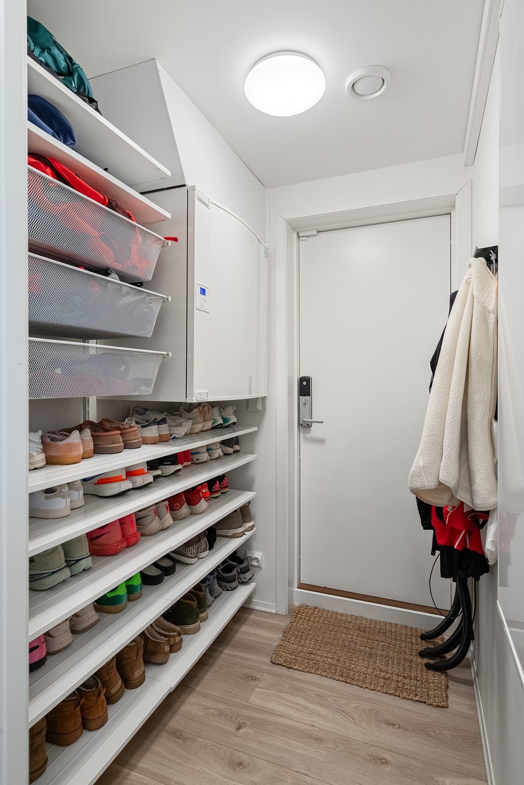 Fra carporten er det direkte adkomst til boligen via en praktisk biinngang med gode oppbevaringsmuligheter for sko og yttertøy. Galleribilde