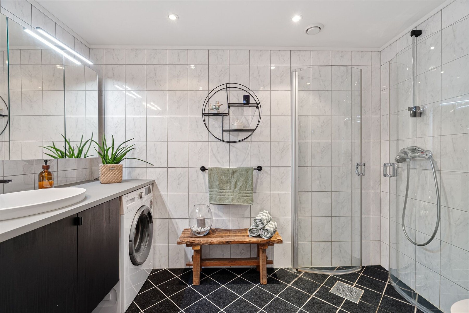 Lyst helfliset bad med behagelig varme i gulv, dusj, opplegg for vaskemaskin og toalett. Badet er oppgradert med ny og moderne servantinnredning og speil. Galleribilde
