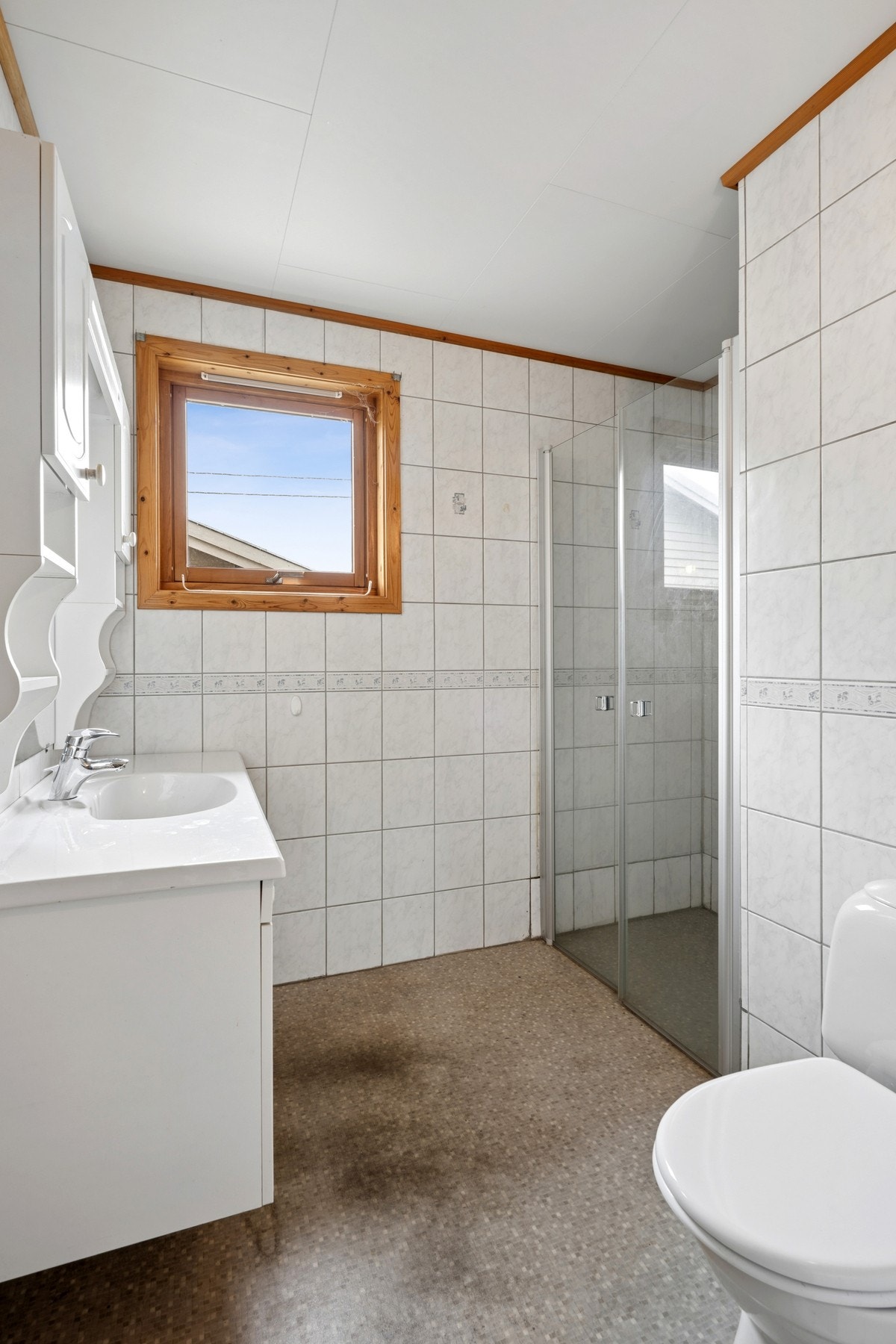 Badet er oppgradert siden byggeår, med fliser på vegg og belegg på gulv. Galleribilde