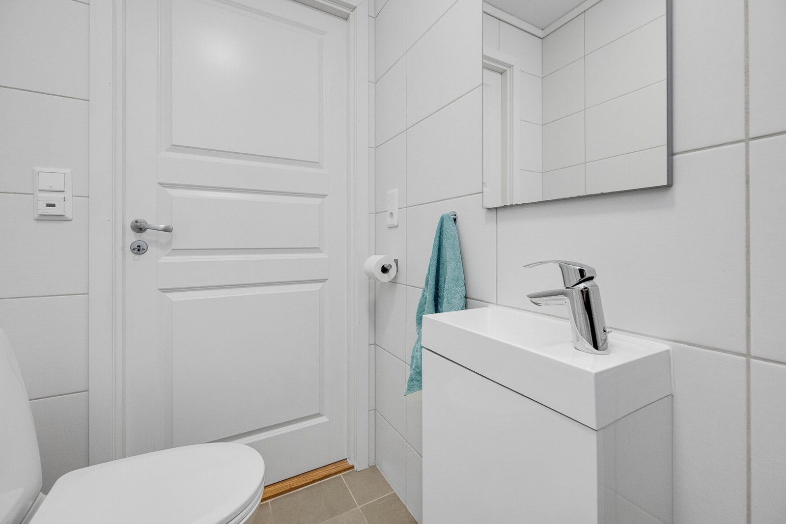 Badet er innredet med toalett, dusjhjørne og servant med innredning og speil. Rommet har mekanisk avtrekk og tilluft via spalte under døren. Galleribilde